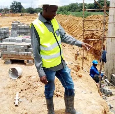 Site supervisor in a hi-vis vest directing work